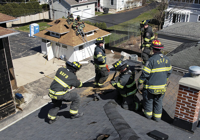 During training, firefighters have the rare opportunity to practice cutting holes in the roof of an actual building.  Photo courtesy 
of the Village of Downers Grove